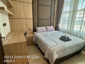une chambre avec un lit avec une grande fenêtre dans l'établissement Cozzi Homestay Sibu, à Sibu