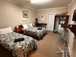 a hotel room with two beds and a kitchen at ALPINE COUNTRY MOTEL plus FREE COFFEE in Cooma