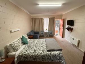 a bedroom with a bed and a living room at ALPINE COUNTRY MOTEL 4mile in Cooma