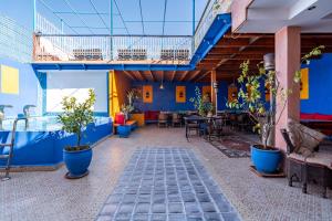 une terrasse avec des plantes en pot et un mur bleu dans l'établissement Maison KA, à Marrakech