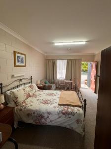 a bedroom with a bed and a living room at ALPINE COUNTRY MOTEL plus FREE COFFEE in Cooma