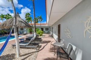 パーム・イーグル・ビーチにあるArubiana Inn Hotelのリゾートパティオ(椅子、ハンモック、プール付)