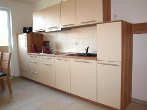a kitchen with white cabinets and a sink at Ferienwohnung Graal Müritz im Igelring in Graal-Müritz