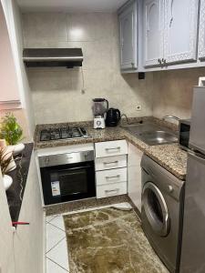 Una pequeña cocina con estufa y fregadero. en Studio, en Marrakech