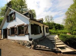 a white house with black windows and a driveway at WesterOurthe 2 personen Sauna in Durbuy