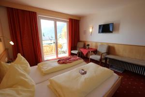 una camera d'albergo con due letti e una finestra di Tannenhof a Ehrwald