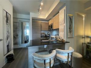 a kitchen with a counter with two bar stools at Toronto Bloor & Yonge Luxury Condo in Toronto
