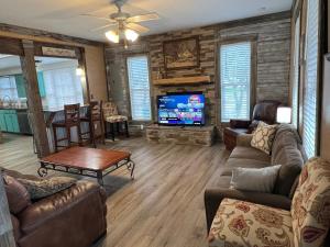 a living room with leather furniture and a flat screen tv at Farmhouse, Private Pool, Spa and Gym! Waco 30 min in Gatesville