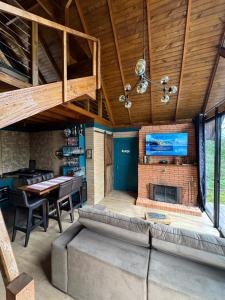 a living room with a couch and a fireplace at Chalé Brisa Verde in Rio dos Cedros