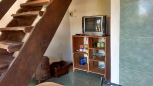 sala de estar con TV y escalera en Del carmen chica, en Villa Giardino