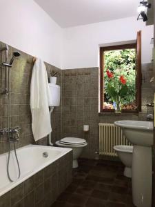 a bathroom with a tub and a sink and a toilet at Casa privata con splendida vista lago "Il Gallicantus" in Nesso +27 photos