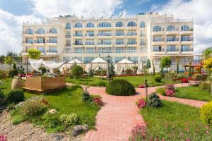 um hotel com um jardim e um edifício em Therma Palace - Private Beach & Free Parking em Kranevo