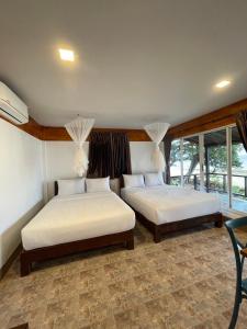 a bedroom with two beds in a room with windows at Phi Phi Private Beach Resort in Phi Phi Don +62 photos