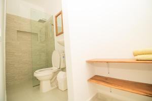 a bathroom with a toilet and a glass shower at Moon House Aparta Estudio - Para 1 o 2 personas in Mompos