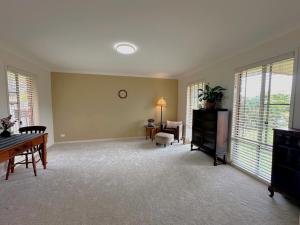a living room with a table and chairs and windows at Driftwood Dream - Tweed Coast Holidays in Pottsville