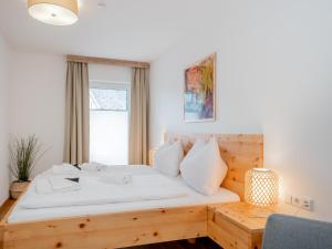 sypialnia z drewnianym łóżkiem i oknem w obiekcie Ski Nature Apartment Lungau Top 8 w mieście Mauterndorf