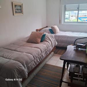 a room with two beds and a table and a window at apartmento punta del este playa mansa in Punta del Este +6 photos