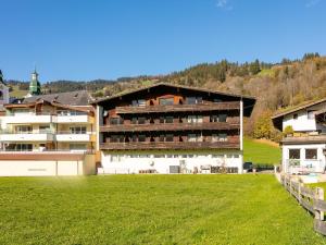 a large building with a green field in front of it at Brixen Alpin Living Top 3 in Brixen im Thale