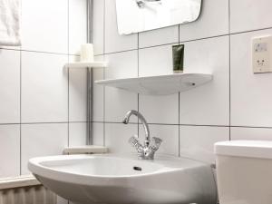 a white bathroom with a sink and a mirror at Brixen Alpin Living Top 16 in Brixen im Thale