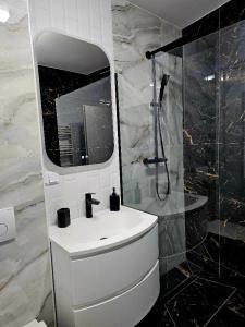 a bathroom with a white sink and a shower at Concept Luxury in Mediaş +90 photos