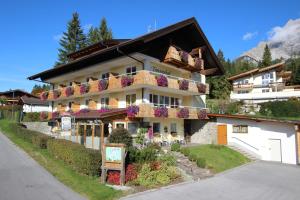 ein Gebäude mit Blumen auf den Balkonen in der Unterkunft Tannenhof in Ehrwald