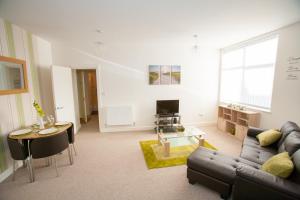 a living room with a couch and a table at Comfortable Swindon Town Centre Apartments, FREE Parking, sleeps up to 8 in Swindon