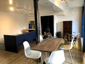 a dining room with a table and white chairs at Petit loft entre Strasbourg et campagne in Reichstett