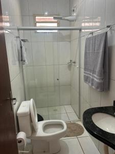 a bathroom with a shower and a toilet and a sink at Casa jardim ao lado da BR-242 in Barreiras +16 photos