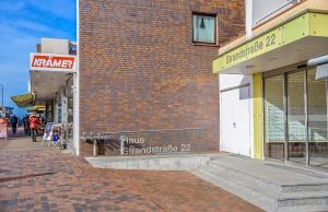 un bâtiment en briques avec une enseigne sur le côté dans l'établissement Bollmann, à Westerland