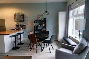 a living room with a dining table and chairs at High Tide - Waterfront bachelor in Tofino