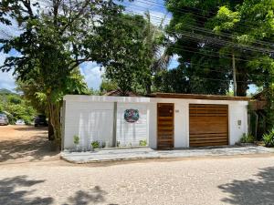 a small white garage with two doors on a street at Chez Jojo in Trancoso
