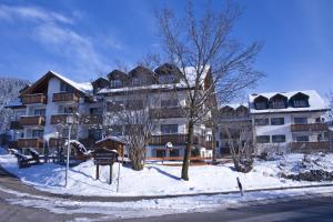 a large apartment building with snow on the ground at Appartements Alpenresidenz in Weitnau