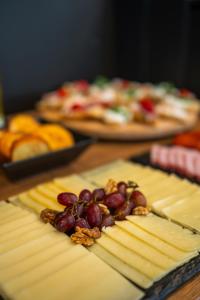 a wooden table with cheese and grapes and other foods at Casablanca Boutique Bed&Breakfast in Zagreb