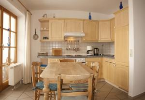 a kitchen with wooden cabinets and a table and chairs at Appartements Alpenresidenz in Weitnau