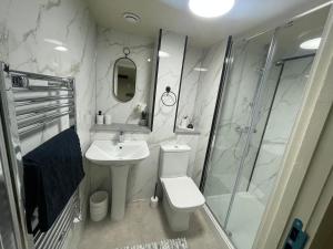 a bathroom with a toilet and a sink and a shower at Stylish Mezzanine Apartment In Central Leeds in Central Station +17 photos