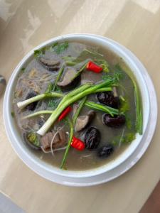 a bowl of soup with meat and vegetables on a table at Khách sạn Vĩnh Lộc in Lao Cai