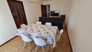 a dining room with a table and white chairs at Avenida Argentina in Monte Hermoso