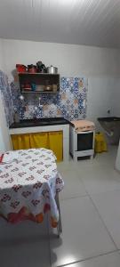 y cocina con cama y microondas. en kitnet da Ana, en Arraial do Cabo