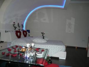 a room with a bed and a table with a blue light at Esperando in Maroni +37 photos