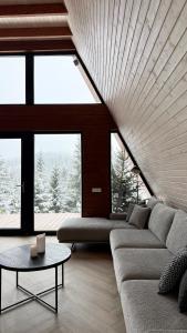 a living room with a couch and a table at Monteluce Aframe in Mărişel +25 photos