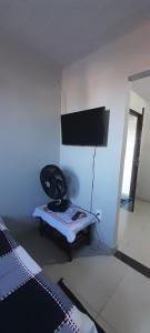 Un dormitorio con una cama y una silla en una habitación. en kitnet da Ana, en Arraial do Cabo 4 fotos más