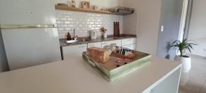 una cocina blanca con una barra con pan. en Maschwitz Norte, en Ingeniero Maschwitz