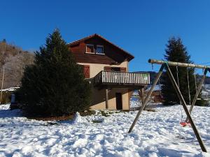 a swing in the snow in front of a house at Chalet familial Vosges avec baby-foot et animaux admis - FR-1-589-688 in Ventron