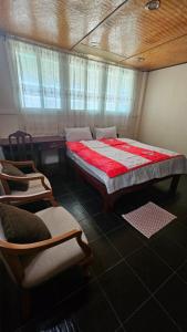a bedroom with a large bed and two chairs at Baan Suan Resort Doisaket 1 in Ban Tha