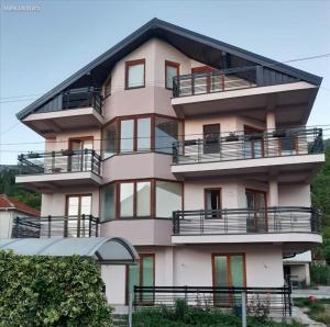 Un gran edificio rosa con balcones. en Amelia Accommodation Pestani Ohrid, en Ohrid