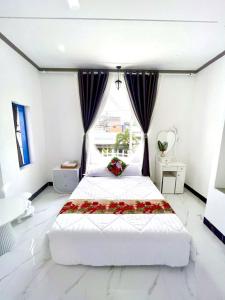 a bedroom with a large bed with flowers on it at Hoàng Nga 1 Homestay in Phan Thiet