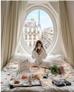a woman sitting on a bed with a table of food at Hoàng Nga 1 Homestay in Phan Thiet