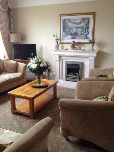 a living room with a fireplace and a coffee table at The Bebington in Bebington