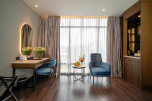 a living room with a desk and a blue chair at Nhat Ha Lavish Hotel in Ho Chi Minh City