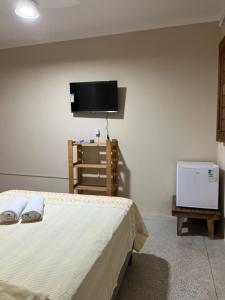a bedroom with a bed and a flat screen tv at Pousada Maria Moura in Camacari +42 photos